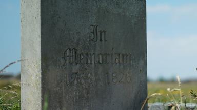 "Lost Places – Geheime Welten - Verlorenes Empire": Ein alter Grabstein auf einer Wiese.