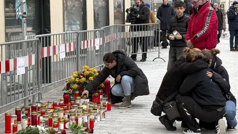 Trauernde Personen am Tatort des Messerangriffs in Villach, aufgenommen am 16.02.2025 