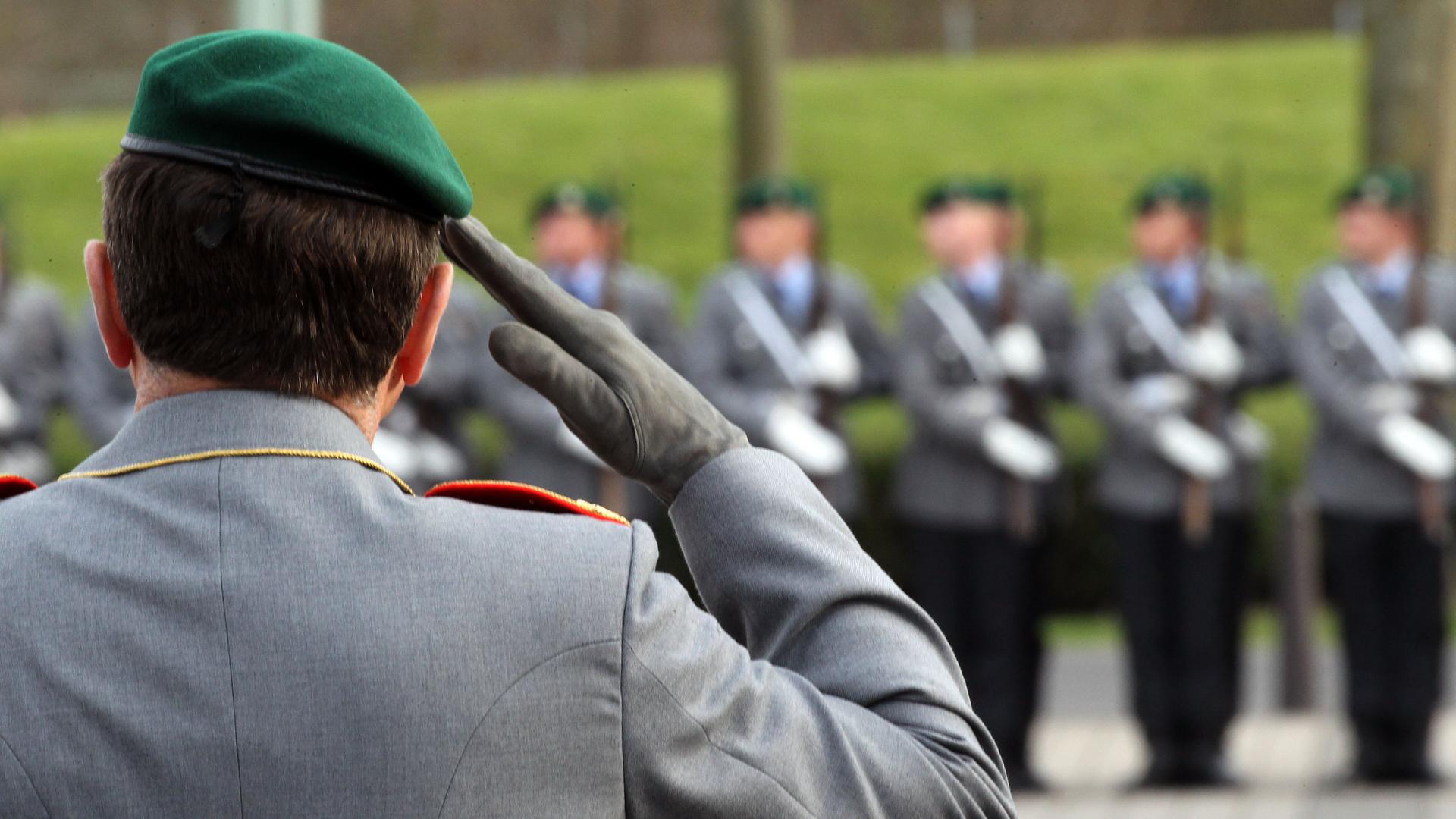 Offizier der Bundeswehr im Hintergrund Männer