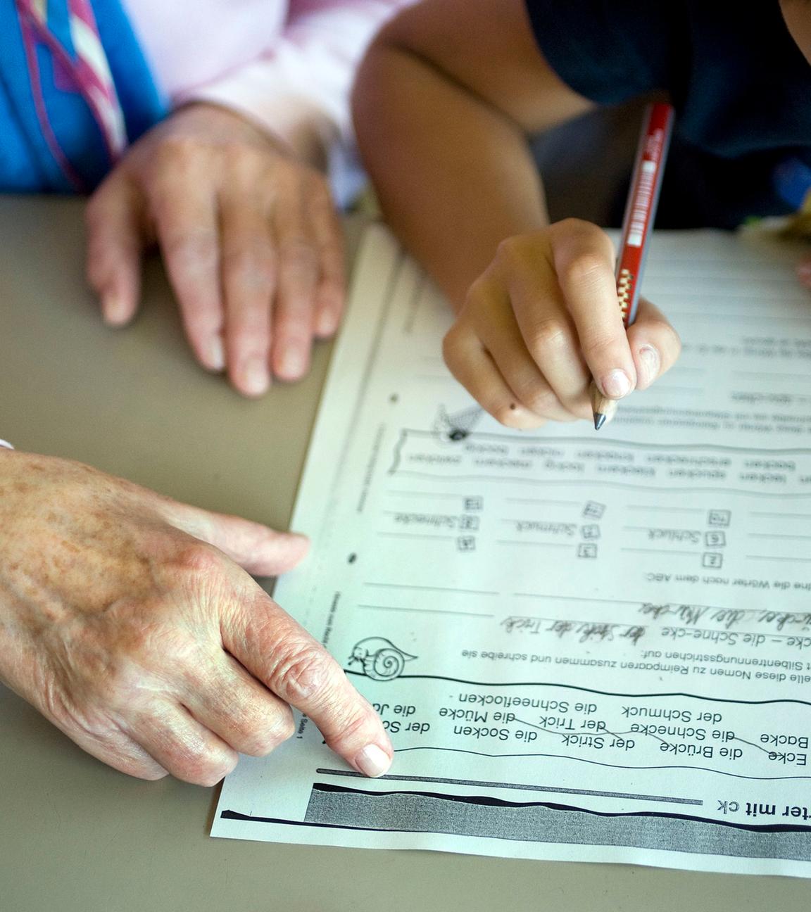 Eine Seniorin hilft am Dienstag (31.08.2010) während der ehrenamtlichen Hausaufgabenhilfe von sechs engagierte Seniorinnen, einem Grundschüler