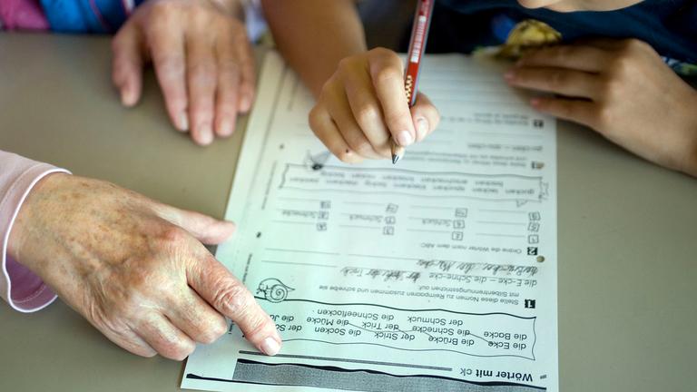 Eine Seniorin hilft am Dienstag (31.08.2010) während der ehrenamtlichen Hausaufgabenhilfe von sechs engagierte Seniorinnen, einem Grundschüler