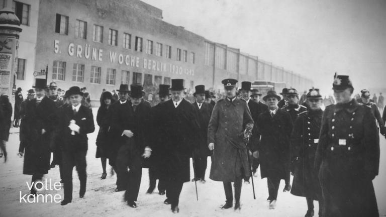 Ein historisches Schwarz-Weiß-Bild von vielen Männern vor einem Gebäude in Berlin