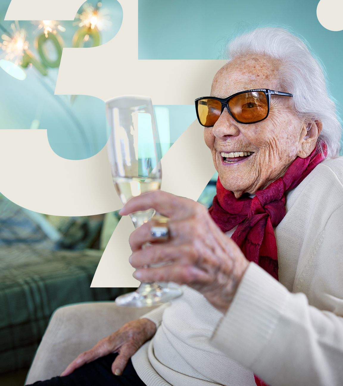 eine hundertjährige Frau, lachend mit einem Glas Sekt in der Hand