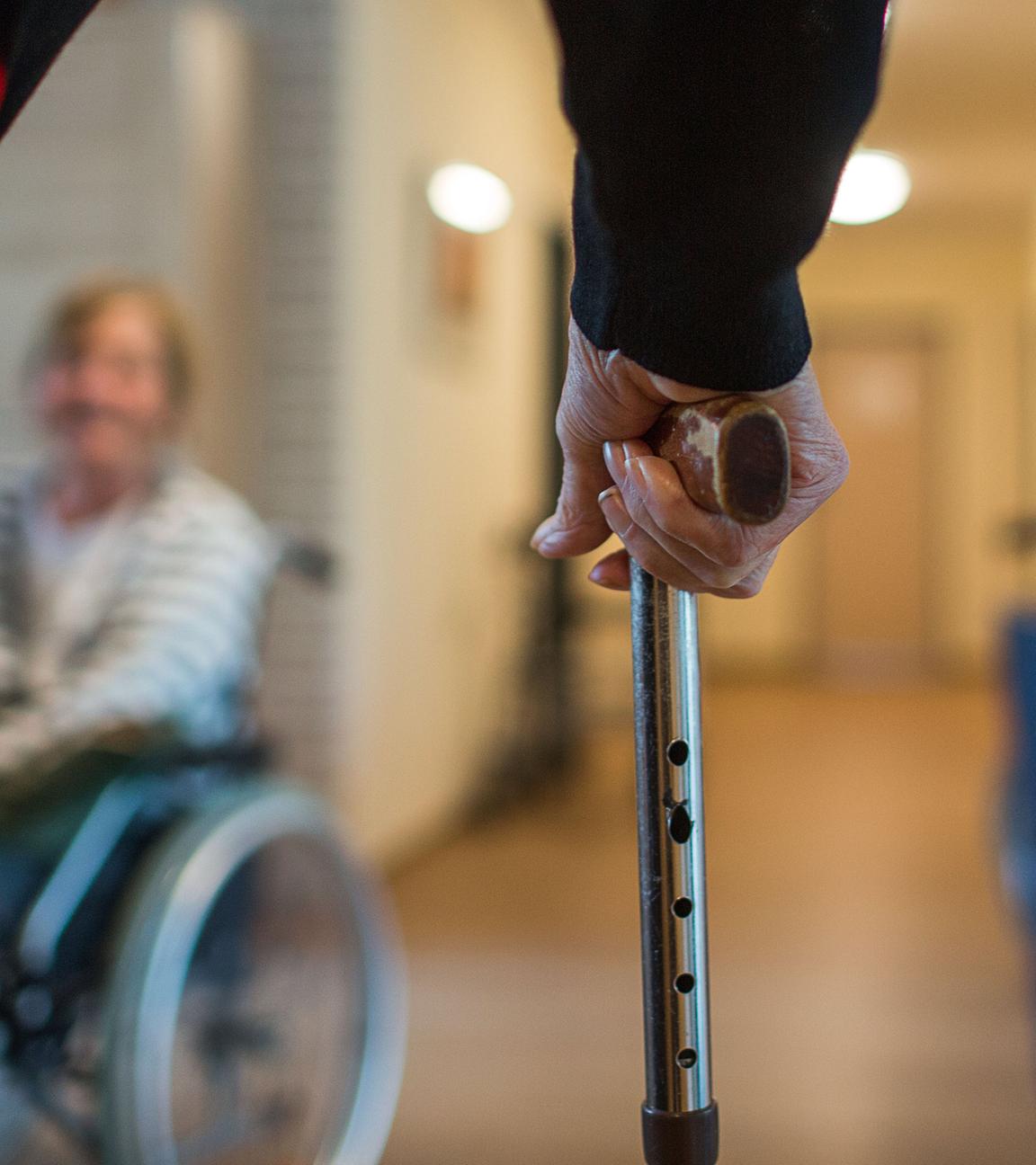 Mann mit Gehstock im Pflegeheim