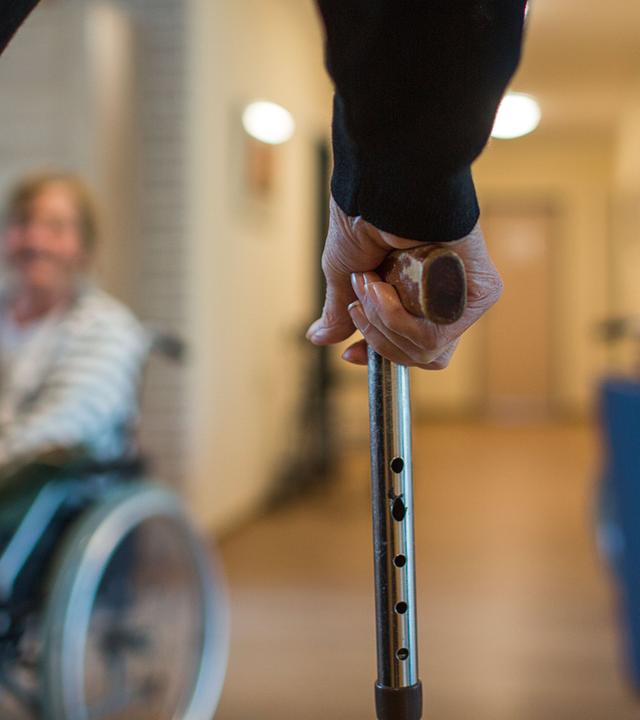 Mann mit Gehstock im Pflegeheim