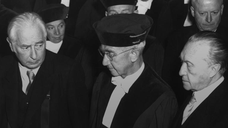 Bundespräsident Theodor Heuss (von links nach rechts), Dr. Hermann Höpker-Aschoff, der erste Präsident des Bundesverfassungsgerichts, und Bundeskanzler Konrad Adenauer während der Feierstunde zur Eröffnung des Bundesverfassungsgerichts tim Kleinen Haus des Badischen Staatstheaters am 28.09.1951 in Karlsruhe.