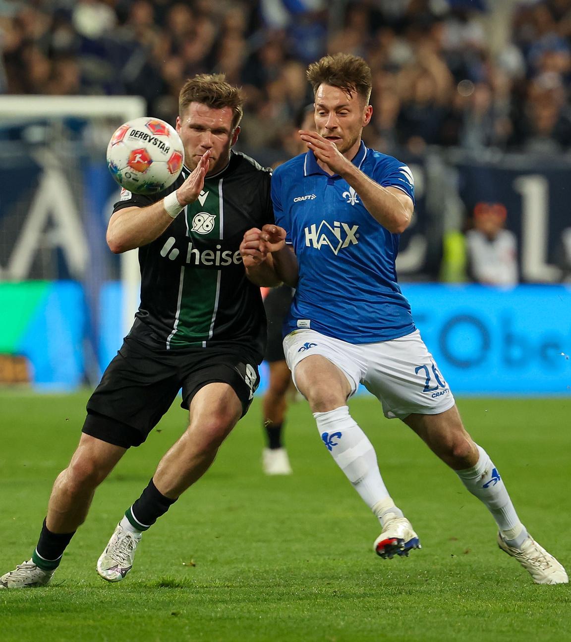 Benjamin Kaellman (Hannover 96) und Matthias Bader (SV Darmstadt 98) im Zweikampf am 11.04.2026 in Darmstadt.