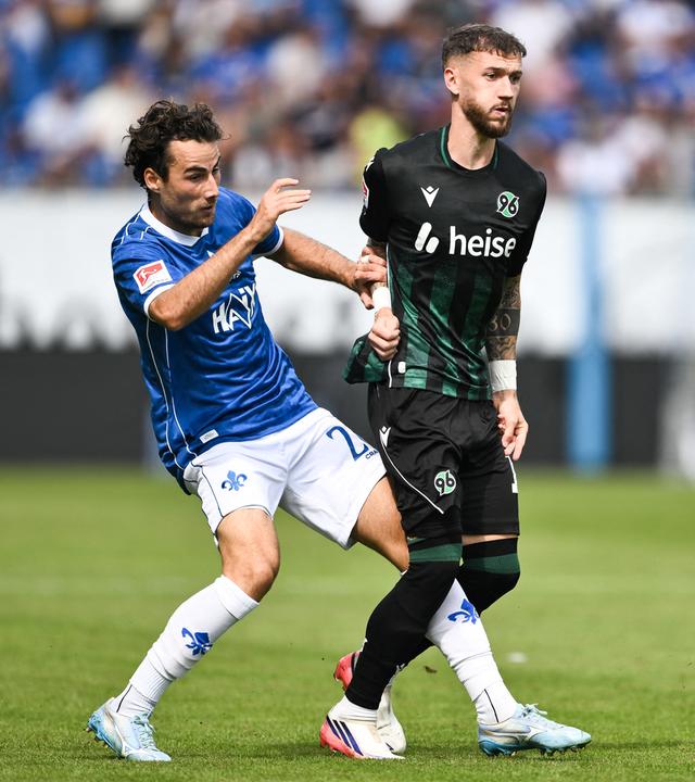 Christopher Lannert (SV Darmstadt 98, l) und Marcel Hartel (Hannover 96) kämpfen um den Ball am 30.08.2026 in Darmstadt. 