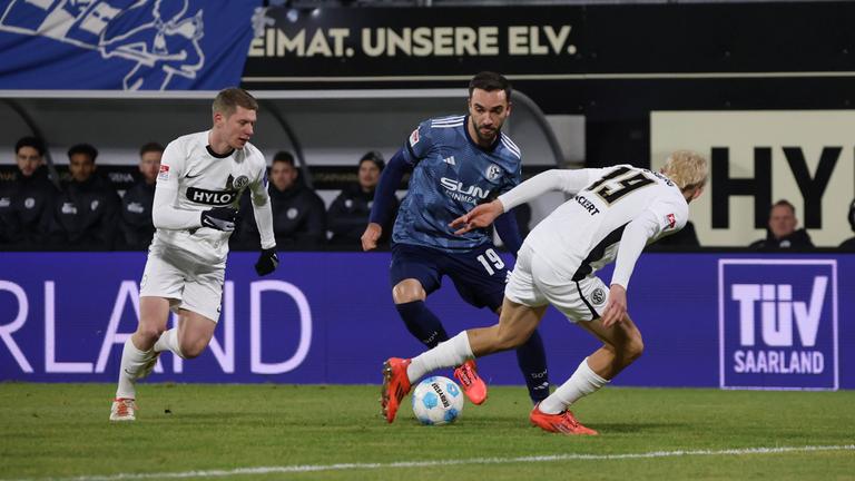 Schalkes Kenan Karamankämpft um den Ball gegen Lukas Pinckert und Elias Baum vom SV Elversberg.