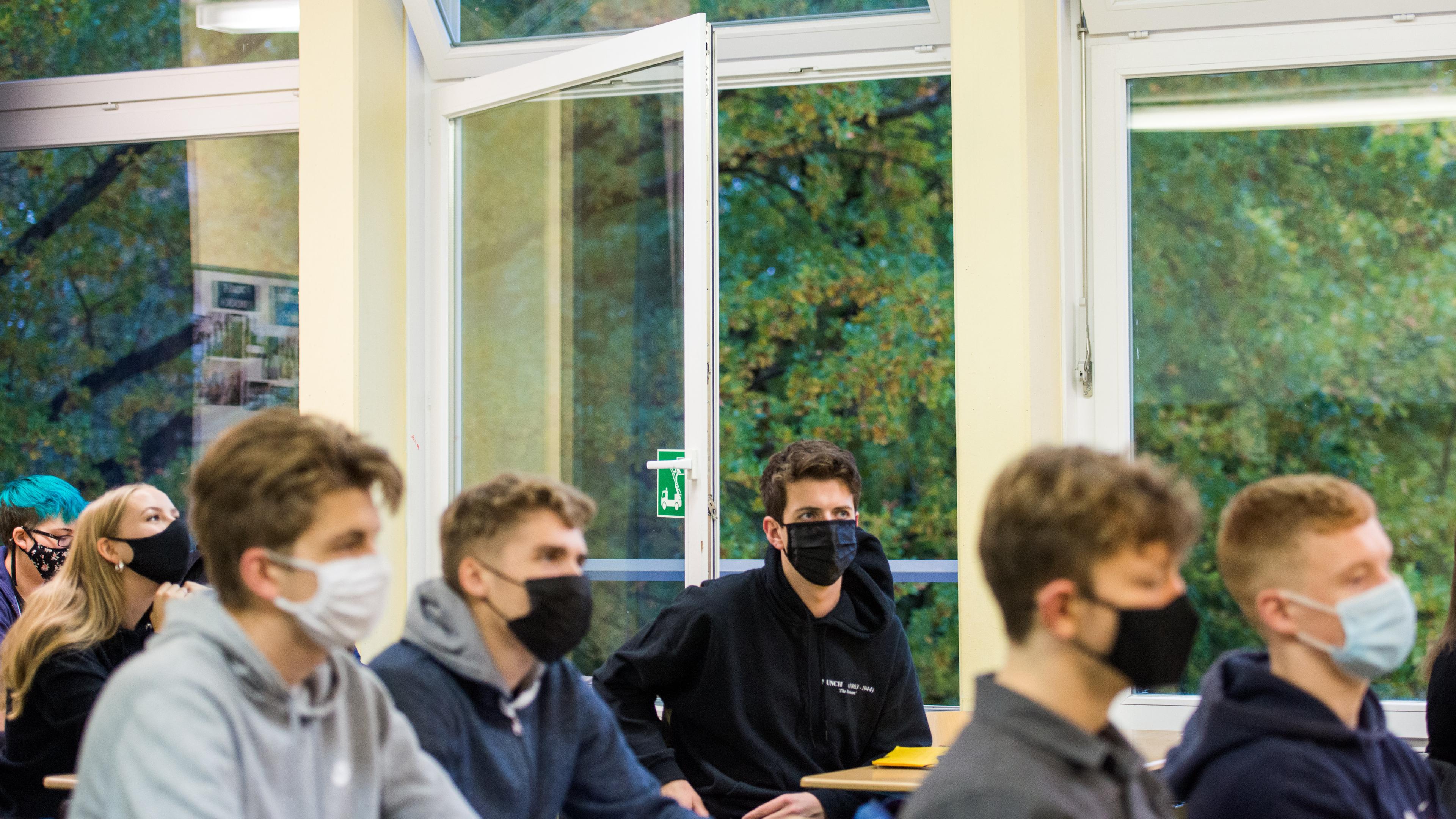 Hamburg: Schüler einer 13.Klasse der Oberstufe der Stadtteilschule Niendorf sitzen mit Masken (Mund-Nasen-Bedeckungen) im Deutsch-Unterricht vor einem geöffneten Fenster. Nach zwei Wochen Herbstferien hat an Hamburgs Schulen wieder der Unterricht begonnen. Für Berufsschüler und die Schüler an den Oberstufen der allgemeinbildenden Schulen gelten verschärfte Corona-Bedingungen.