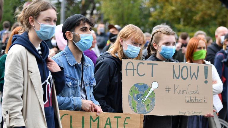 DemonstrantInnen der Fridays for Future Bewegung halten Plakate hoch.