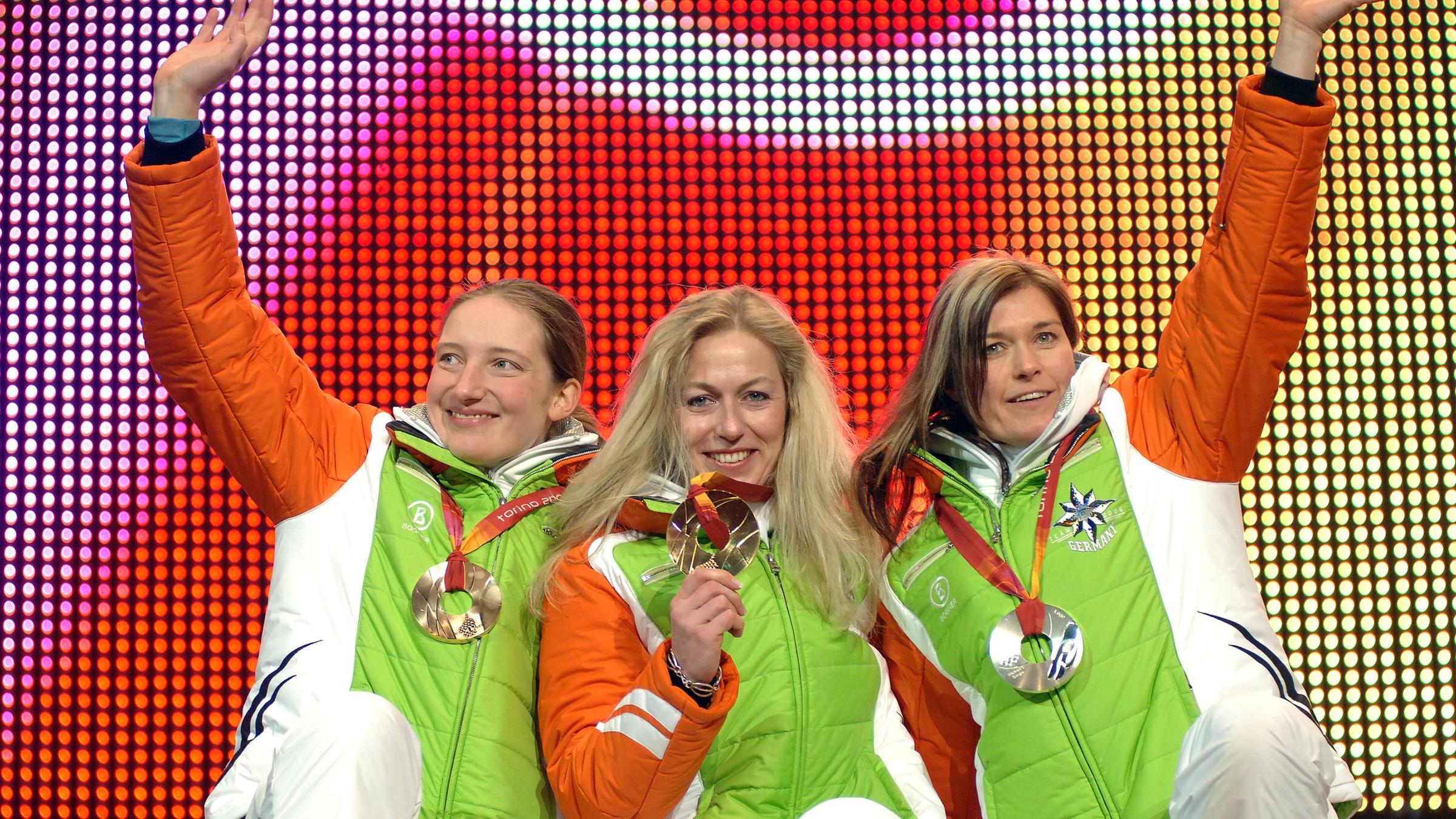 Die deutschen Rennrodlerinnen Sylke Otto, Silke Kraushaar und Tatjana Hüfner präsentieren nach dem Dreifachsieg ihre Medaillen bei den Olympischen Winterspielen 2006 in Turin