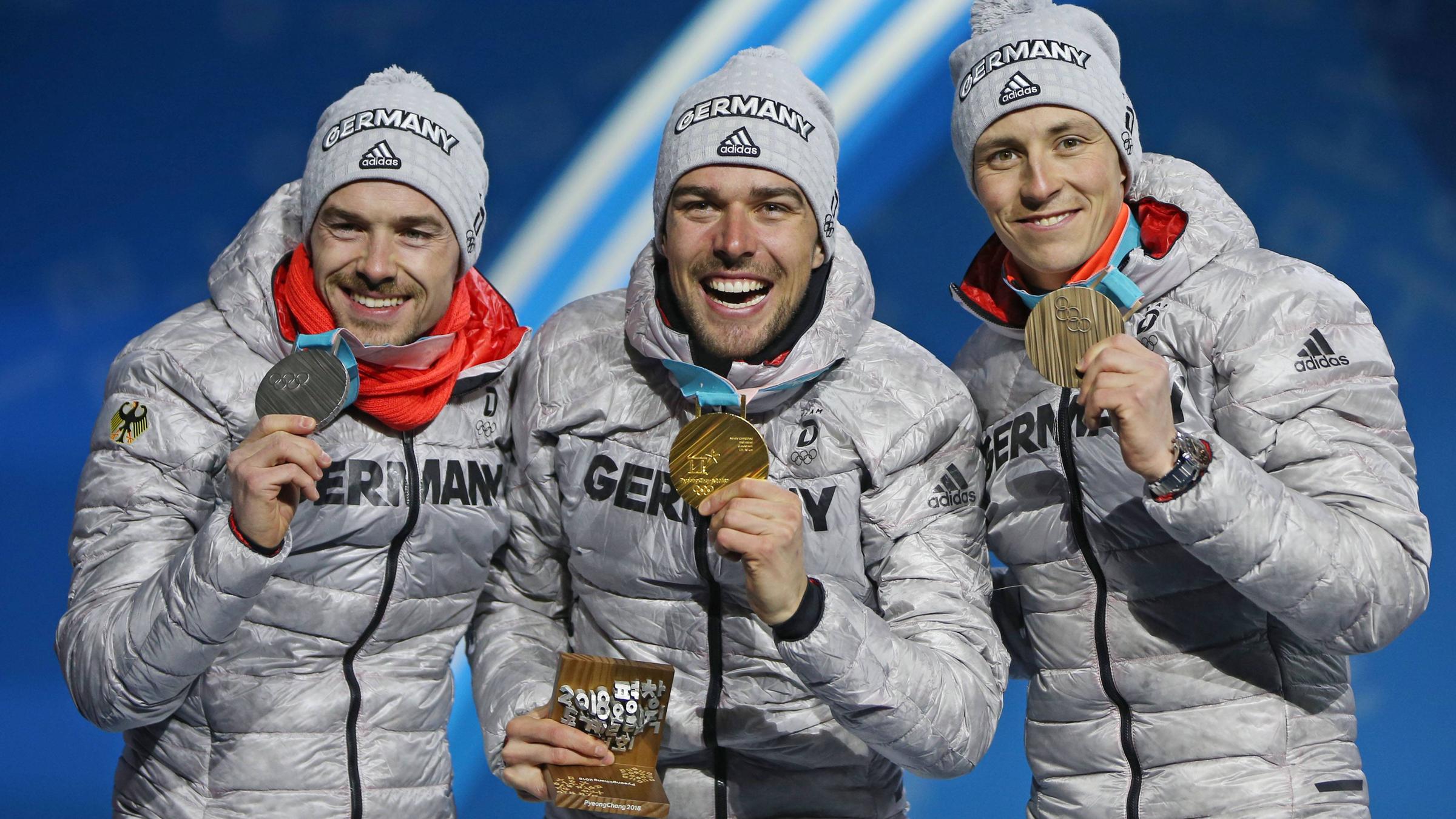 Die deutschen Nordischen Kombinierer Fabian Rießle, Johannes Rydzek und Eric Frenzel (v.l.) jubeln auf dem Podium bei den Olympischen Winterspielen 2018 in Pyeongchang
