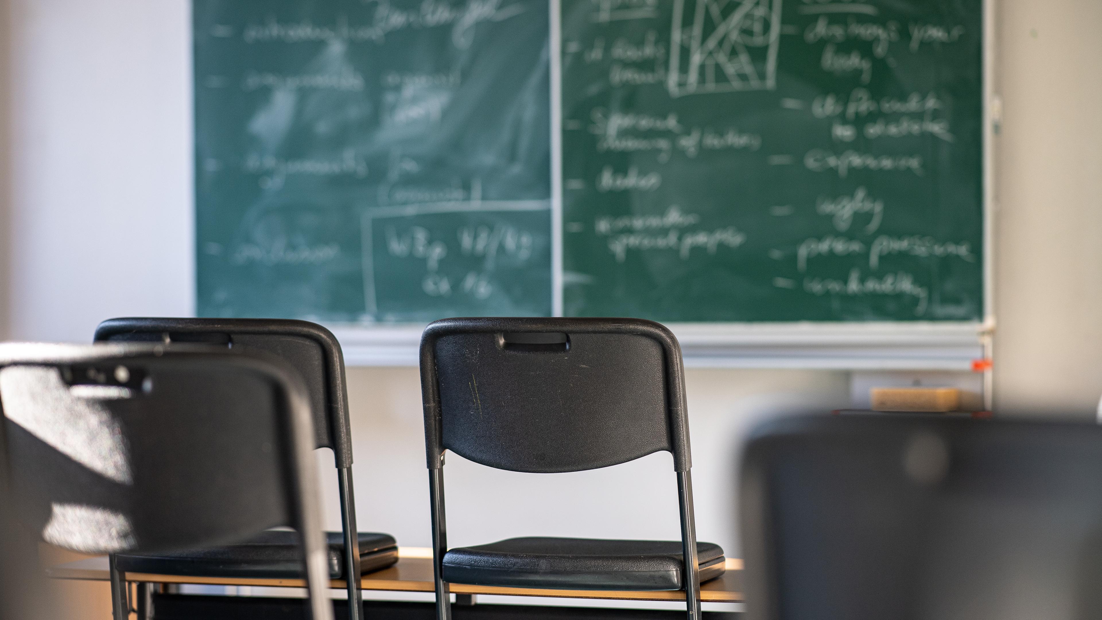 Hochgestellte Stühle in einem leeren Klassenzi