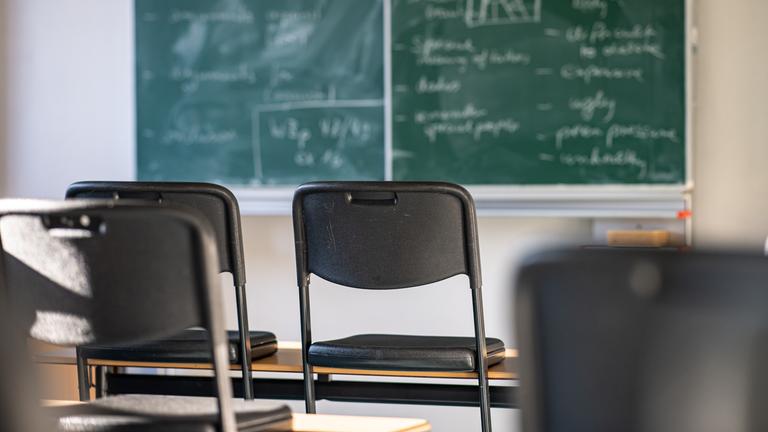 Hochgestellte Stühle in einem leeren Klassenzi