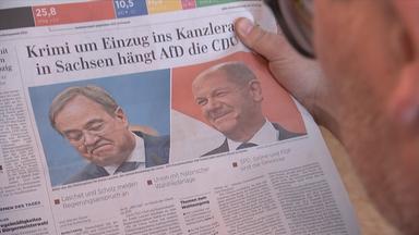 27.09.2021: Ein Zeitungsartikel mit den Bildern von Olaf Scholz (SPD) und Armin Laschet (CDU) und der Überschrift "Krimi um Einzug ins Kanzleramt - in Sachsen hängt AfD die CDU ab" 