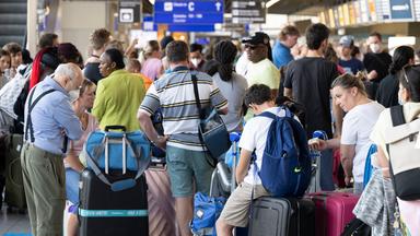Tausende Passagiere warten vor den Abfertigungsschaltern des Flughafens auf ihren Check-In in Frankfurt am Main am 22.07.2022