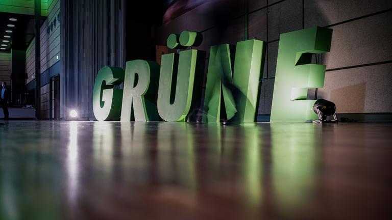 Ein Delegierter geht beim Bundesparteitag von Bündnis 90/Die Grünen am Logo seiner Partei vorbei. Die Bundesdelegiertenkonferenz dauert bis zum 16.10.2022