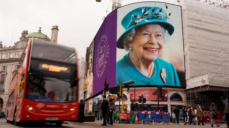 Ein Bus fährt an einer Werbetafel am Piccadilly Circus vorbei, auf der Bilder der britischen Königin anlässlich ihres Platinjubiläums gezeigt werden.