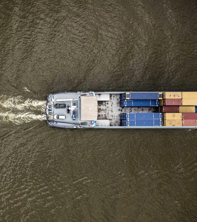 18.08.2022, Rhein bei Lobith, Niederlande: Ein Binnenschiff fährt durch den Rhein (aufgenommen aus der Vogelperspektive)