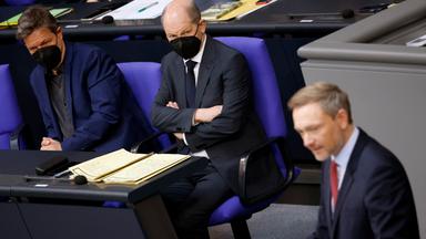 Berlin, Deutschland, 22.03.2022: Finanzminister Christian Lindner (FDP) am Rednerpult. Bundeskanzler Olaf Scholz und Wirtschaftsminister Robert Habeck sitzen links im Hintergrund