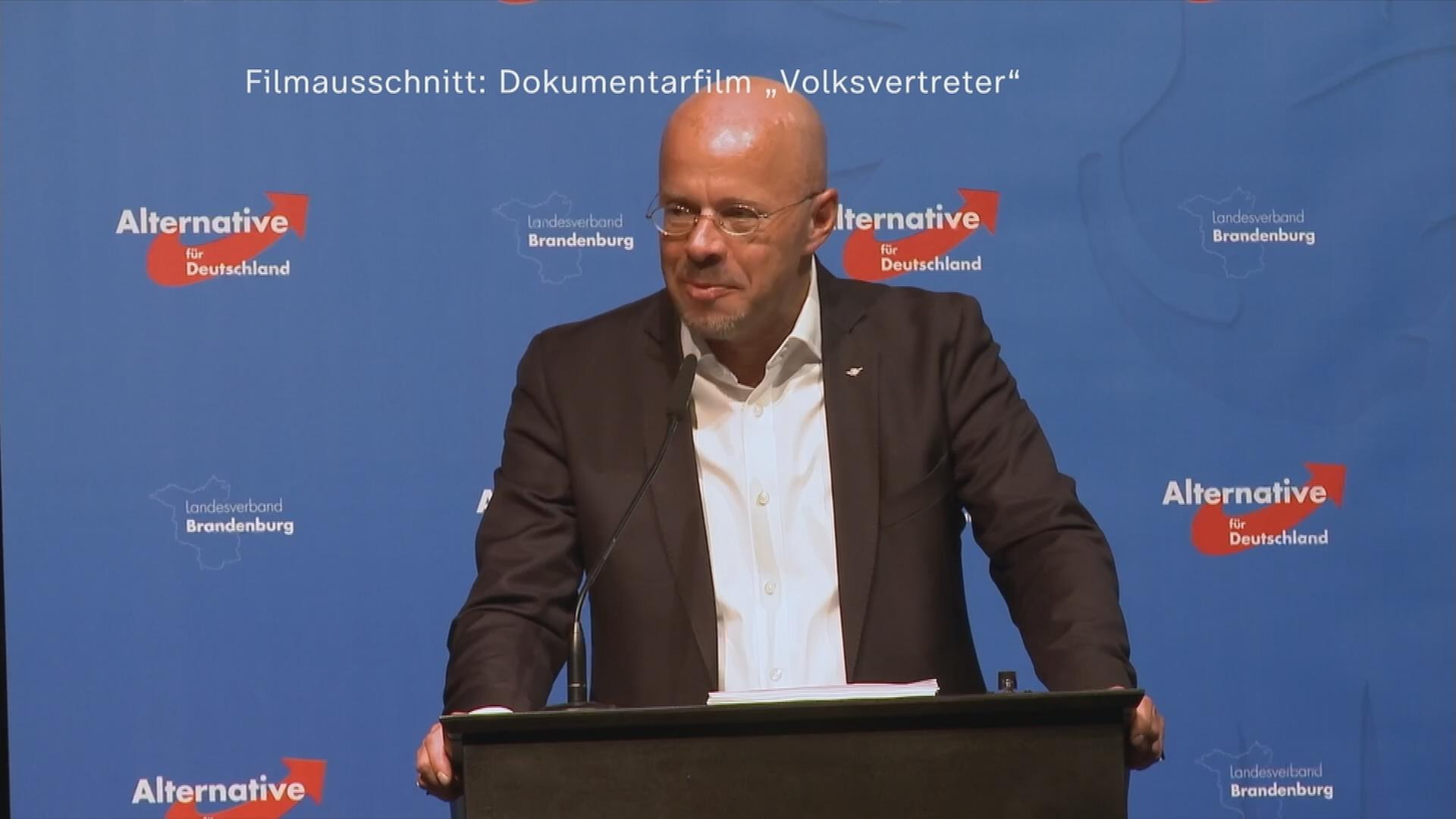 25.05.2022: Andreas Kalbitz spricht an einem Mikrofon: Im Hintergrund das AfD Logo mehrmals zu sehen.