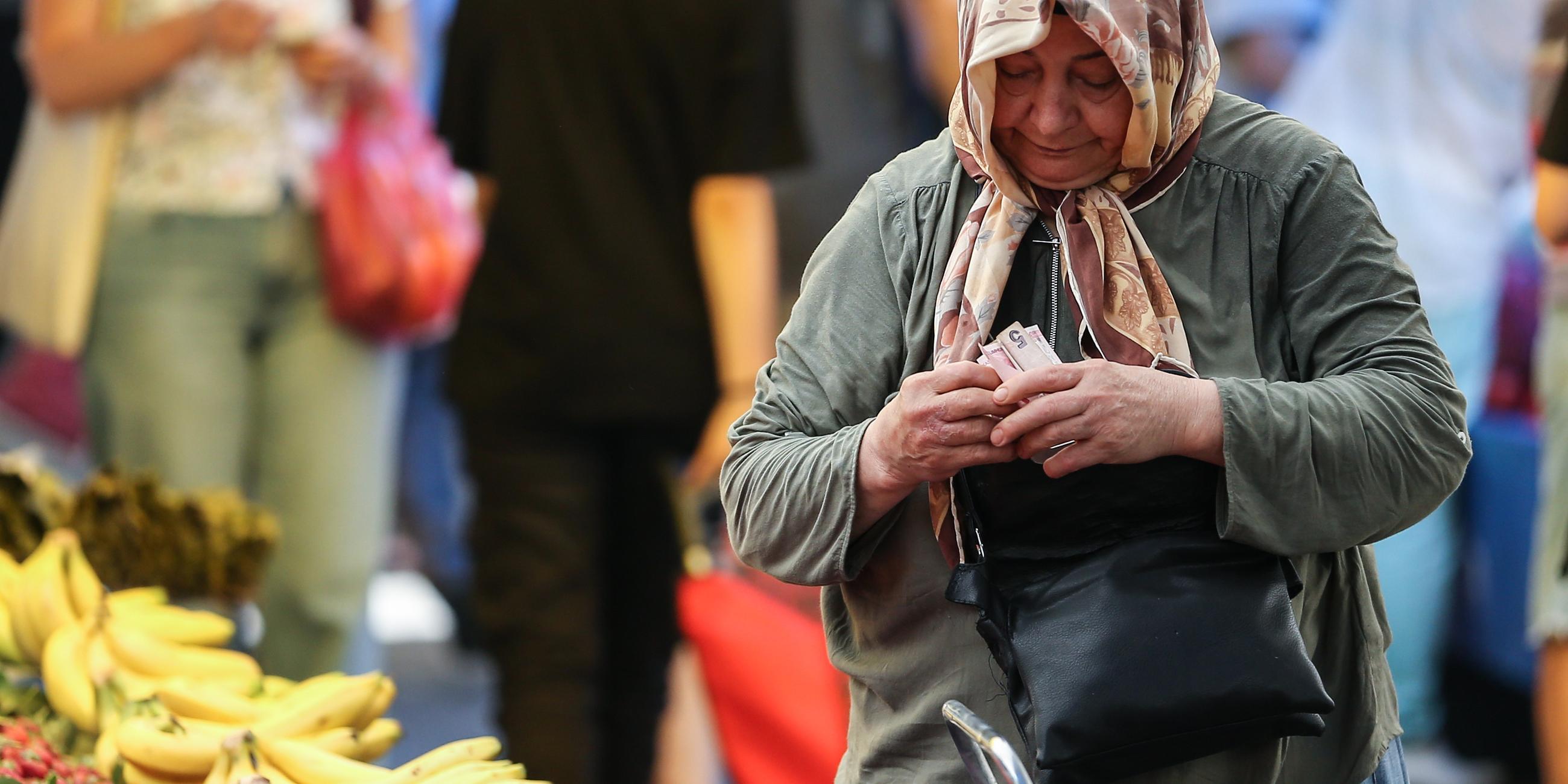 Eine ältere Frau mit Geldscheinen in der Hand 