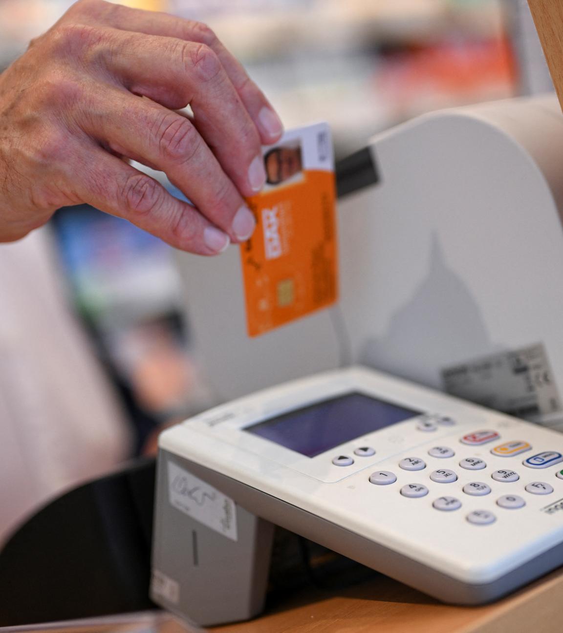 Eine Person legt die Gesundheitskarte eines Patienten in ein Kartenlesegerät in einer Apotheke, während einer Präsentation des neuen Verfahrens zur Ausstellung eines elektronischen Rezepts