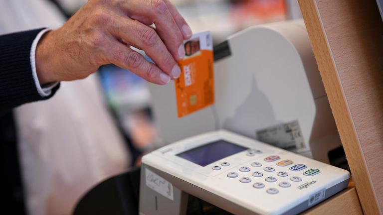 Eine Person legt die Gesundheitskarte eines Patienten in ein Kartenlesegerät in einer Apotheke, während einer Präsentation des neuen Verfahrens zur Ausstellung eines elektronischen Rezepts