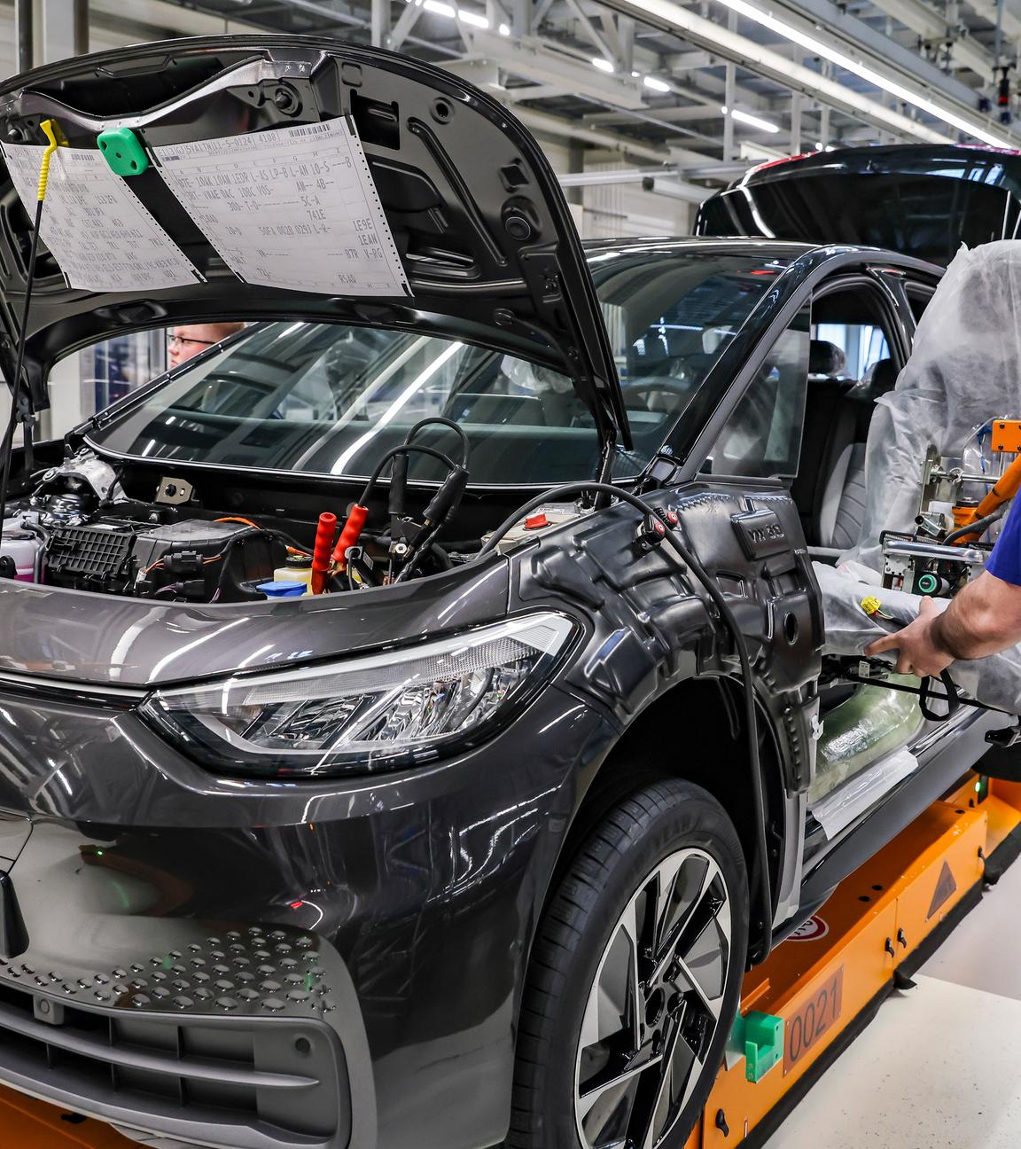 Mitarbeiter montiert Fahrersitz im Werk von Volkswagen in Zwickau
