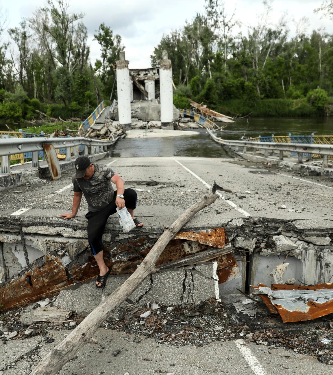 Ein Anwohner überquert den Fluss Siversky Donets auf einer zerstörten Brücke im Dorf Bohorodychne in der Region Donezk, Ukraine, am 30. Mai 2023 (veröffentlicht am 31. Mai 2023). Vor dem Krieg lebten in Bohorodyche etwa 600 Menschen. Heute sind nur noch 18 Menschen in ihre Häuser zurückgekehrt. Russische Truppen marschierten am 24. Februar 2022 in die Ukraine ein und lösten damit einen Konflikt aus, der Zerstörung und eine humanitäre Krise zur Folge hatte.