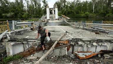 Ein Anwohner überquert den Fluss Siversky Donets auf einer zerstörten Brücke im Dorf Bohorodychne in der Region Donezk, Ukraine, am 30. Mai 2023 (veröffentlicht am 31. Mai 2023). Vor dem Krieg lebten in Bohorodyche etwa 600 Menschen. Heute sind nur noch 18 Menschen in ihre Häuser zurückgekehrt. Russische Truppen marschierten am 24. Februar 2022 in die Ukraine ein und lösten damit einen Konflikt aus, der Zerstörung und eine humanitäre Krise zur Folge hatte.