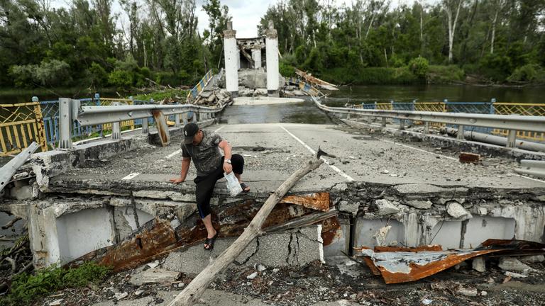 Ein Anwohner überquert den Fluss Siversky Donets auf einer zerstörten Brücke im Dorf Bohorodychne in der Region Donezk, Ukraine, am 30. Mai 2023 (veröffentlicht am 31. Mai 2023). Vor dem Krieg lebten in Bohorodyche etwa 600 Menschen. Heute sind nur noch 18 Menschen in ihre Häuser zurückgekehrt. Russische Truppen marschierten am 24. Februar 2022 in die Ukraine ein und lösten damit einen Konflikt aus, der Zerstörung und eine humanitäre Krise zur Folge hatte.