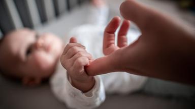 Baby greift nach einer Hand