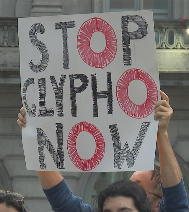 Protestschild während einer Demo mit der Schrift "Stop Glypho now" 