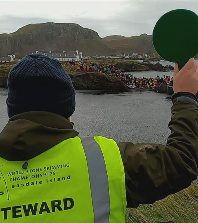 Schottland sucht Weltmeister im Steine hüpfen, Mann steht am See mit einer Startkelle.