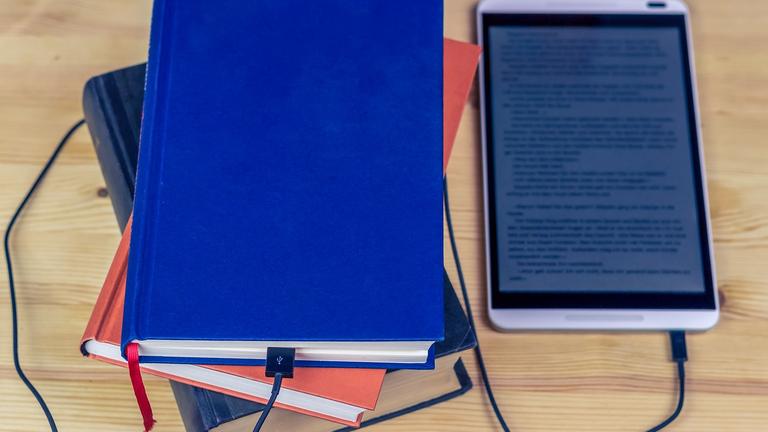 Buch und Tablet liegen nebeneinander