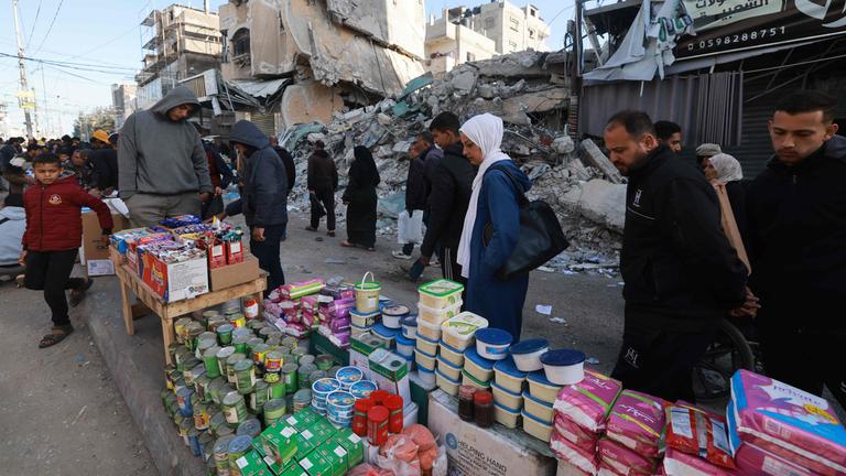 Palästinenser gehen am 10. März 2024 an Ständen vorbei, die in einer Straße in Rafah im südlichen Gazastreifen aufgebaut sind. Die Muslime bereiten sich inmitten der anhaltenden Kämpfe zwischen Israel und der militanten palästinensischen Gruppe Hamas auf den heiligen Fastenmonat Ramadan vor.