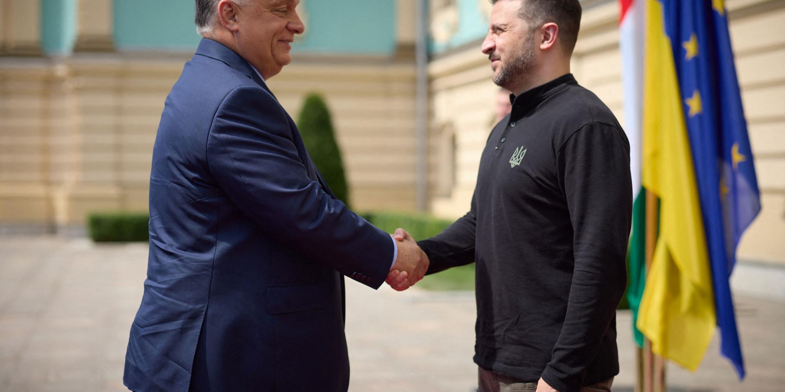 Dieses vom Pressedienst des ukrainischen Präsidenten am 2. Juli 2024 veröffentlichte Foto zeigt den ukrainischen Präsidenten Volodymyr Zelensky (R) beim Händeschütteln mit dem ungarischen Ministerpräsidenten Viktor Orban während dessen Besuch in Kiew inmitten der russischen Invasion in der Ukraine.