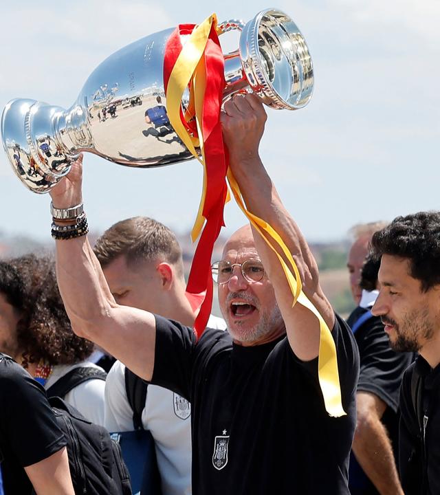paniens Cheftrainer Luis de la Fuente hält den Pokal der UEFA Euro 2024 in die Höhe, während er mit seinen Spielern am 15. Juli 2024, einen Tag nach dem Finalsieg gegen England, am Flughafen Adolfo Suárez Madrid_Barajas in Madrid eintrifft. 