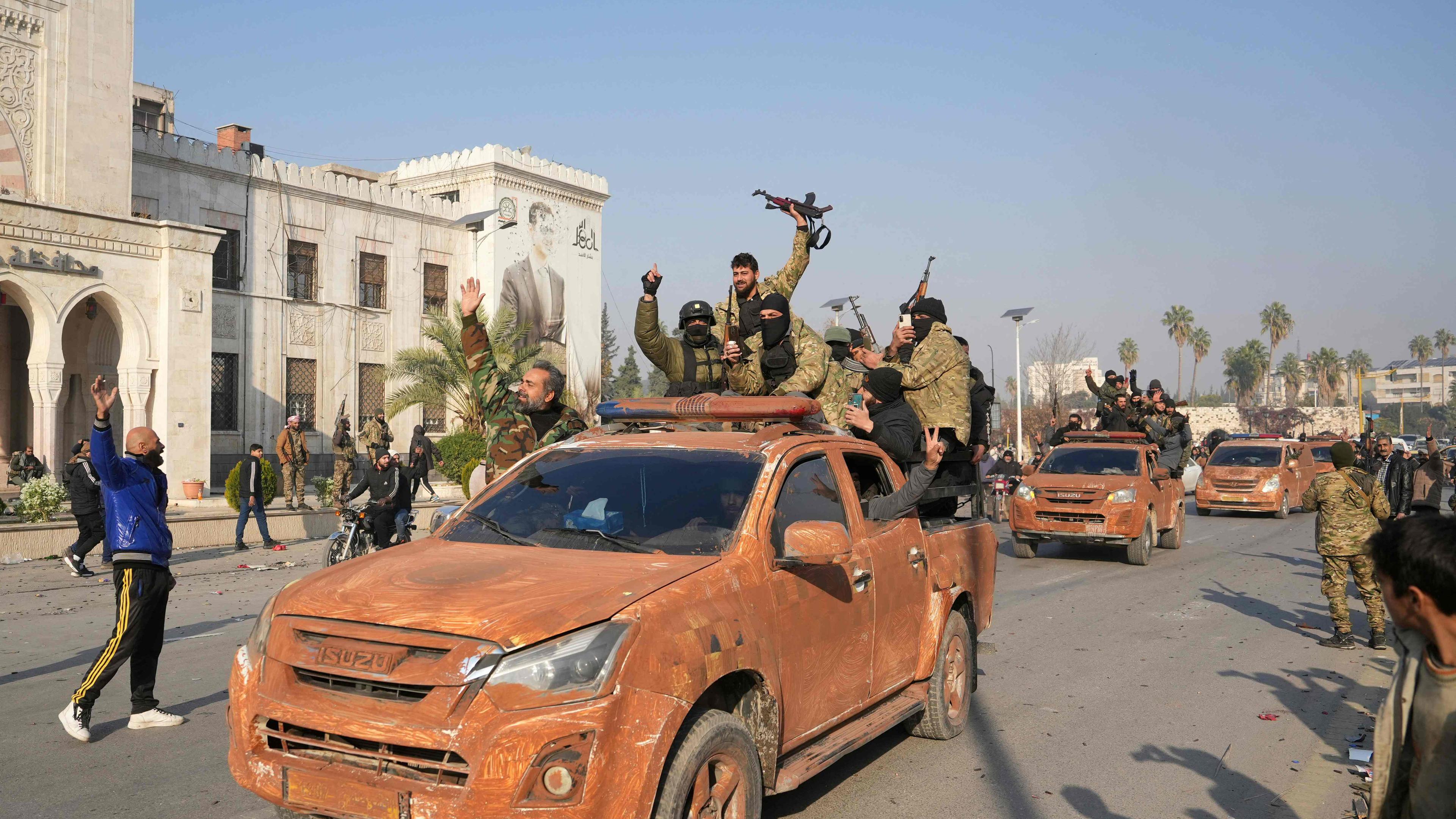 Syrian anti government fighters celebrate as they pour into the captured central-west city of Hama on December 6, 2024. In little over a week, the offensive by rebel forces has seen Syria's second city Aleppo and strategically located Hama fall from President Bashar al-Assad's control for the first time since the civil war began in 2011.