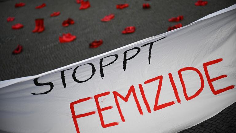 25.11.2024, Berlin: Ein Banner mit der Aufschrift «Stoppt Femizide» hängt vor roten Schuhen, die anlässlich des Internationalen Tags für die Beseitigung von Gewalt gegen Frauen vor dem Rathaus Tiergarten stehen. Die Aktion ist angelehnt an das Projekt «Zapatos Rojos» (dt. Rote Schuhe) der mexikanischen Künstlerin Chauvet, die damit gegen Gewalt an Frauen protestiert.