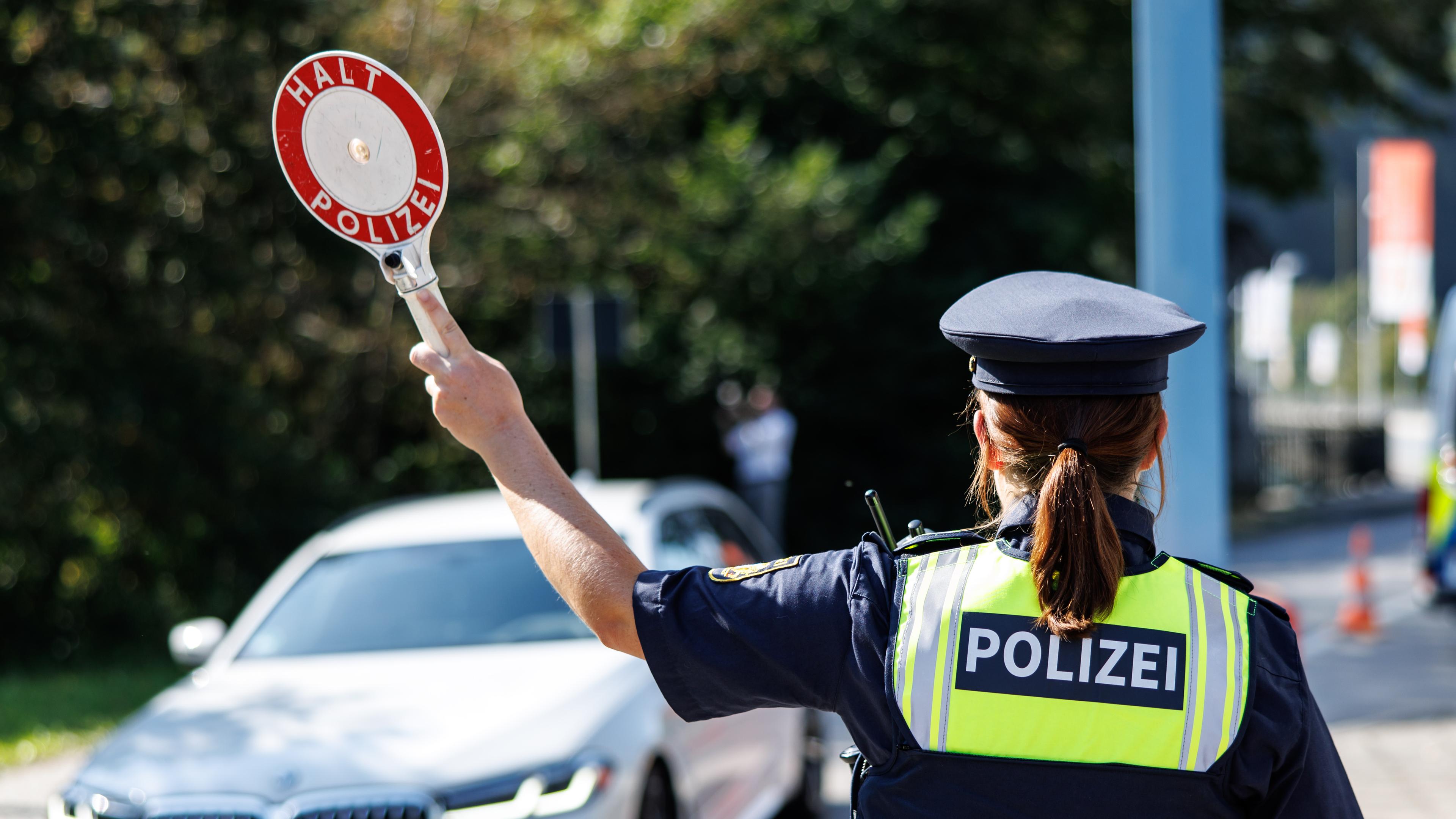 Eine Polizistin der Bayerischen Grenzpolizei stoppt bei einem Pressetermin an einer Kontrollstelle ein Fahrzeug. Bei dem Pressetermin soll über die aktuelle Lage an den bayerischen Grenzen zu Österreich und Tschechien sowie über Maßnahmen zum verstärkten Grenzschutz informiert werden.