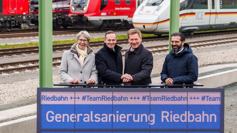 Staatssekretärin im Verkehrsministerium von Baden-Württemberg, Volker Wissing (Parteilos), Bundesverkehrsminister, Richard Lutz, Vorstandsvorsitzender der Deutschen Bahn AG, und Umut Sönmez (SPD), Staatssekretär im Verkehrsministerium Hessen, drücken den symbolischen Startknopf zur Wiederaufnahme des Bahnverkehrs auf der Rieddbahnstrecke nach der Generalsanierung. Nach fünf Monaten Bauzeit ist die Riedbahn zwischen Mannheim und Frankfurt ab Sonntag wieder für Güter- und Personenzüge befahrbar.