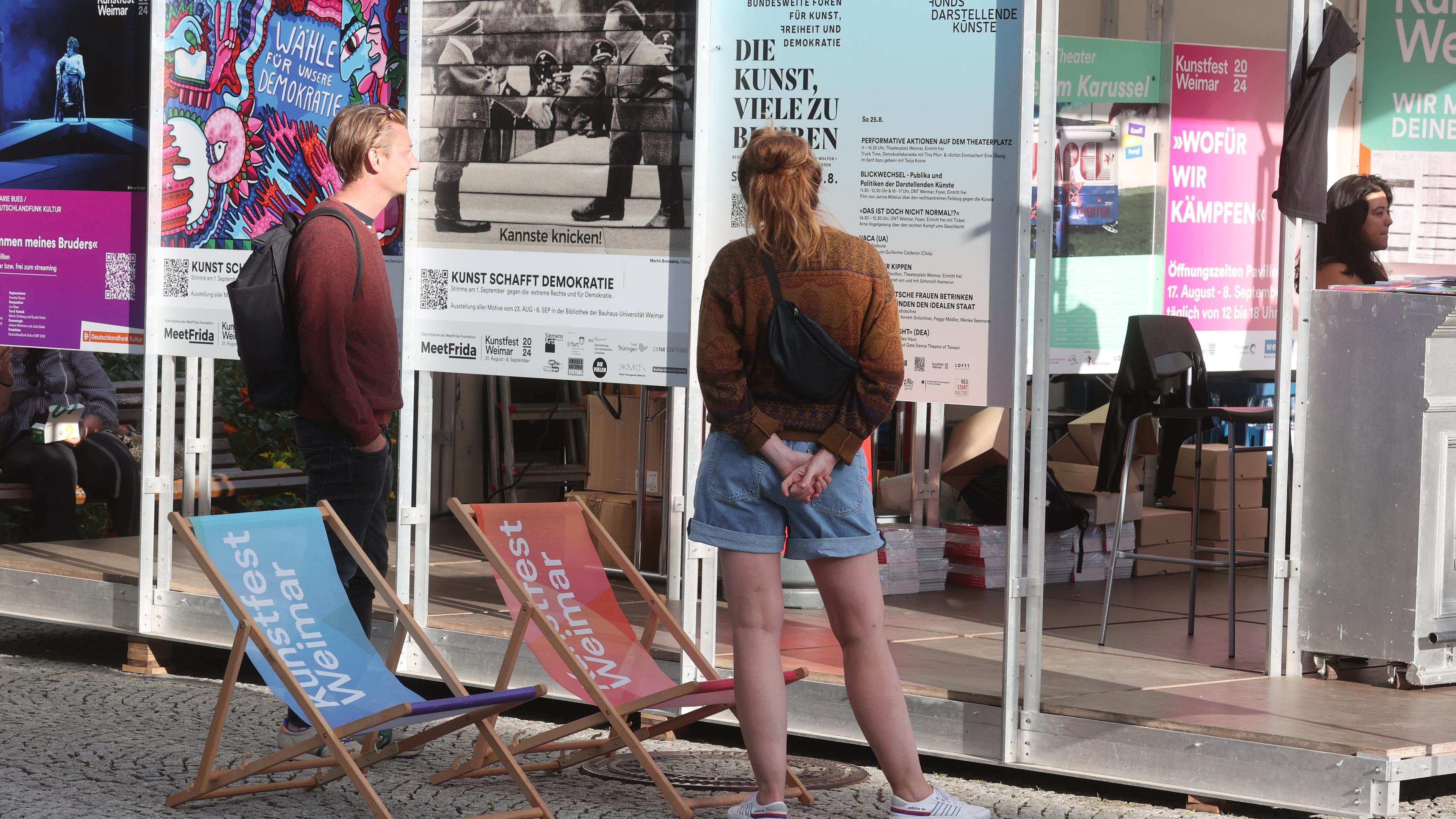 Besucher betrachten Plakate vor der Eröffnung des Kunstfestes Weimar auf dem Theaterplatz. Das Kunstfest Weimar ist eines der wichtigsten Festivals für zeitgenössische Kunst in Deutschland.