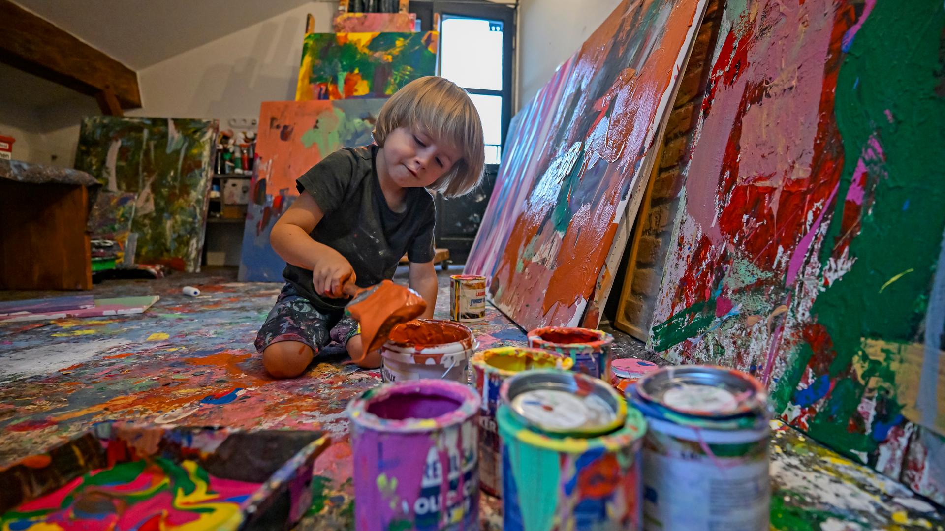 25.08.2024, Bayern, Neubeuern: Laurent Schwarz malt in seinem Atelier grossformatige Bilder mit Acrylfarben.