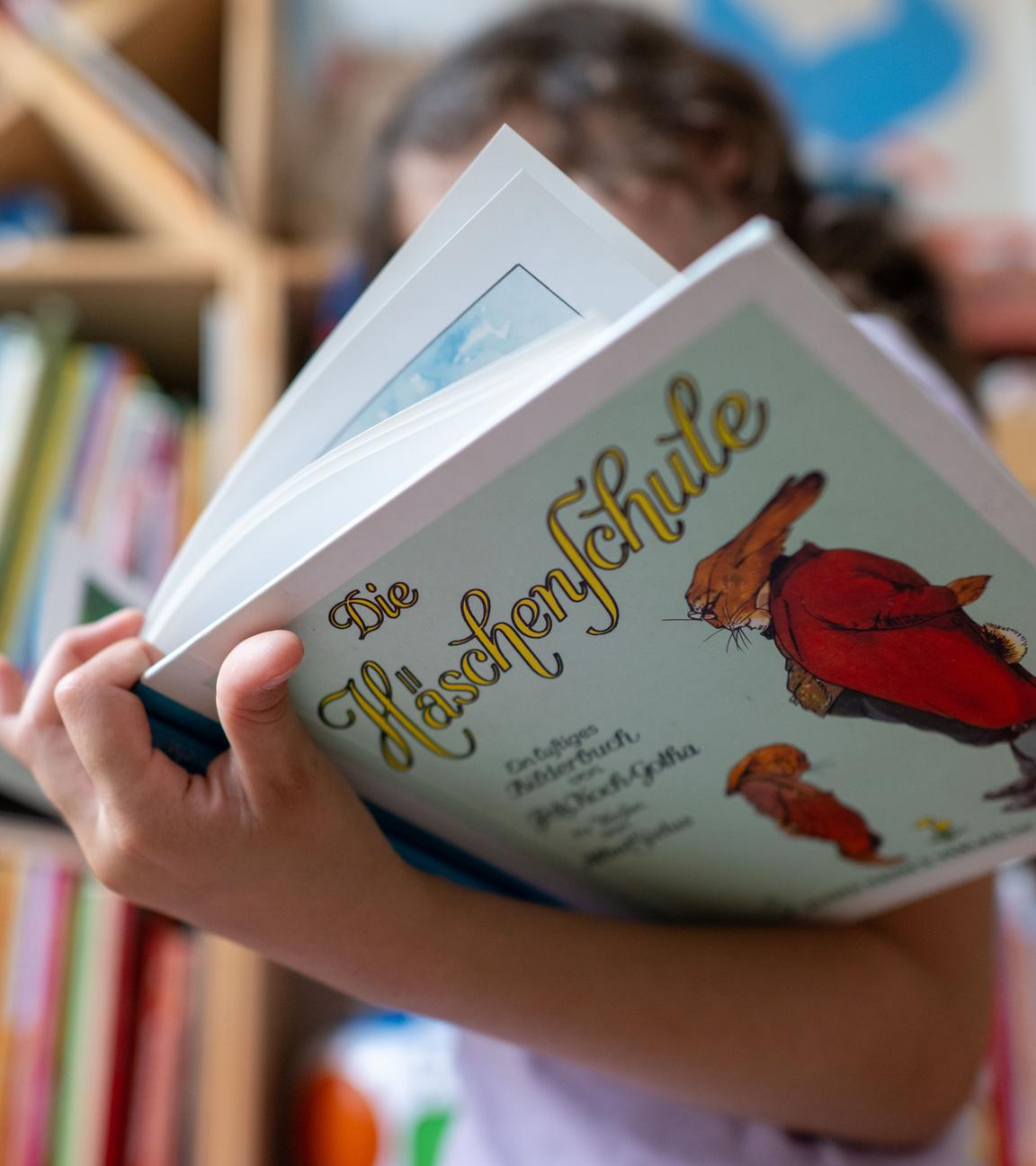 Ein Mädchen hält eine neuere Ausgabe des Kinderbuchs ·Die Häschenschule· (Thienemann-Esslinger Verlag) in ihren Händen. Der Klassiker von Albert Sixtus (1892-1960) wird in diesem Jahr 100 Jahre alt. Sixtus, damals Lehrer im sächsischen Kirchberg, hat die Verse in nur einer Nacht Ende April 1922 niedergeschrieben. Bis zur Veröffentlichung vergingen gut zwei Jahre. Vor 100 Jahren im Spätsommer 1924 erschien die Geschichte dann als Buch mit Illustrationen von Fritz Koch-Gotha