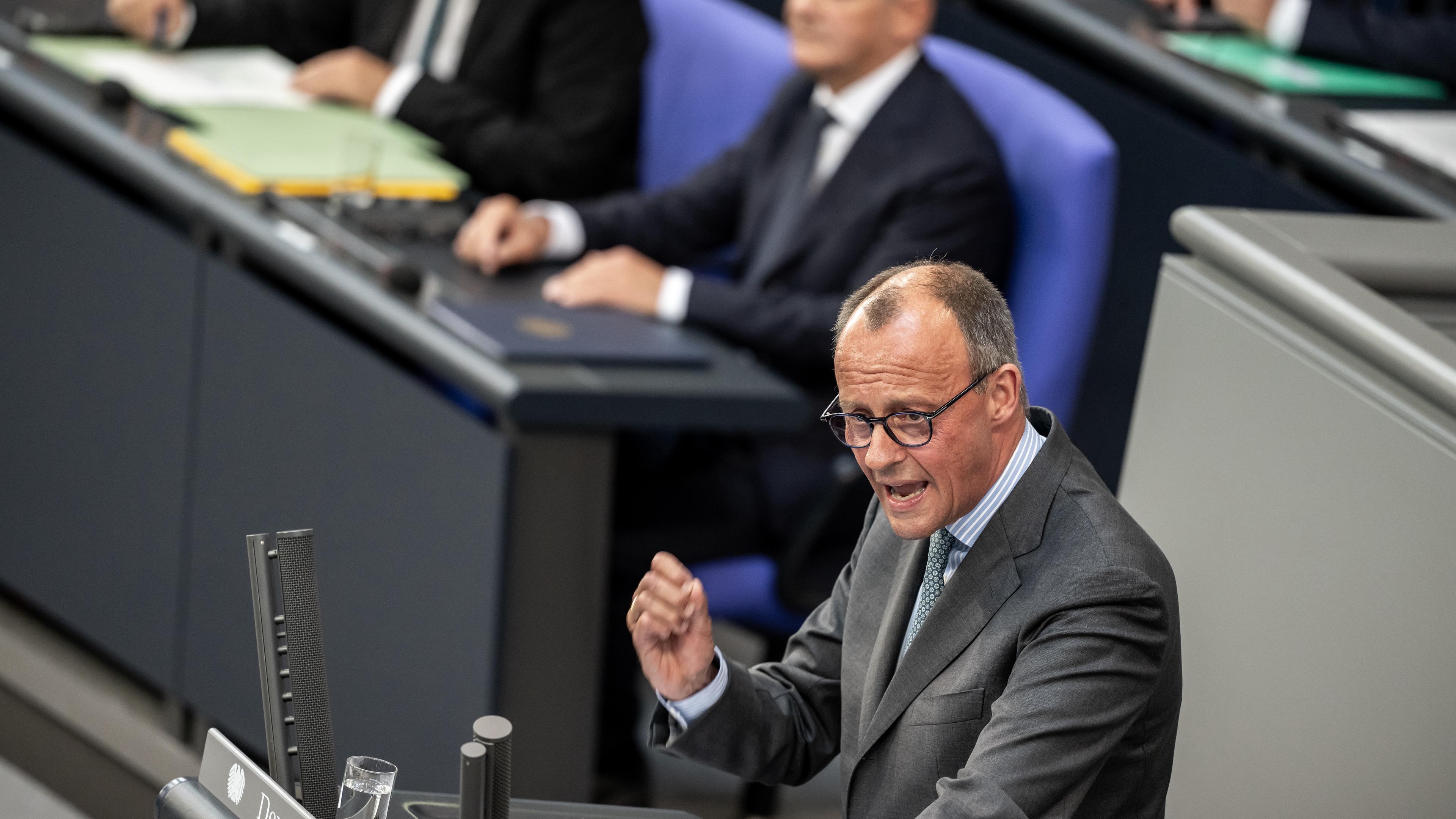 26.06.2024, Berlin: Friedrich Merz (vorn), CDU-Bundesvorsitzender und CDU/CSU Fraktionsvorsitzender im Bundestag, spricht vor Bundeskanzler Olaf Scholz (SPD), nach der Regierungserklärung zu den Gipfeltreffen von EU und NATO im Bundestag.