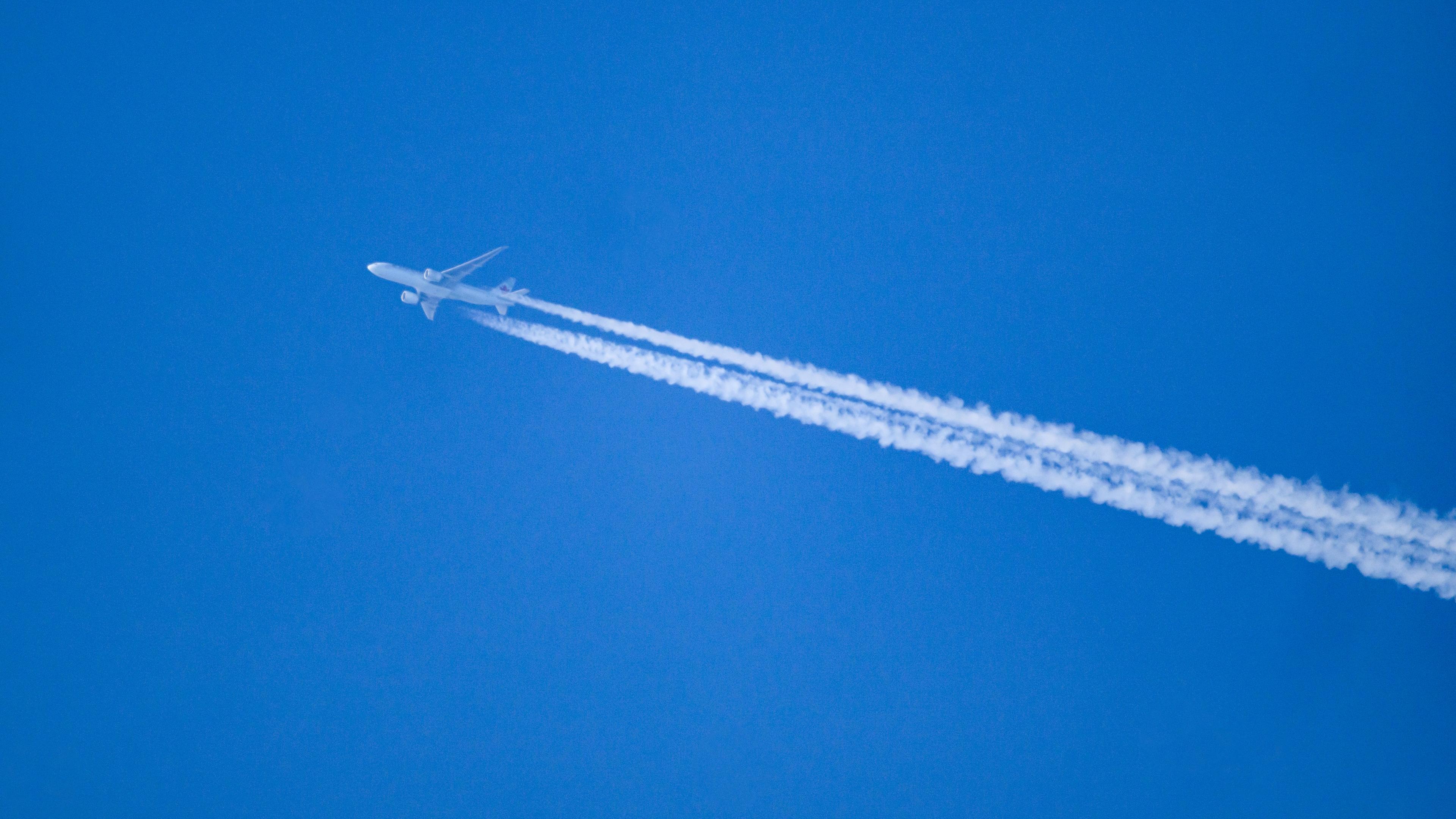 Ein Flugzeug hinterlässt Kondensstreifen am blauen Himmel im südlichen Rheinland-Pfalz 