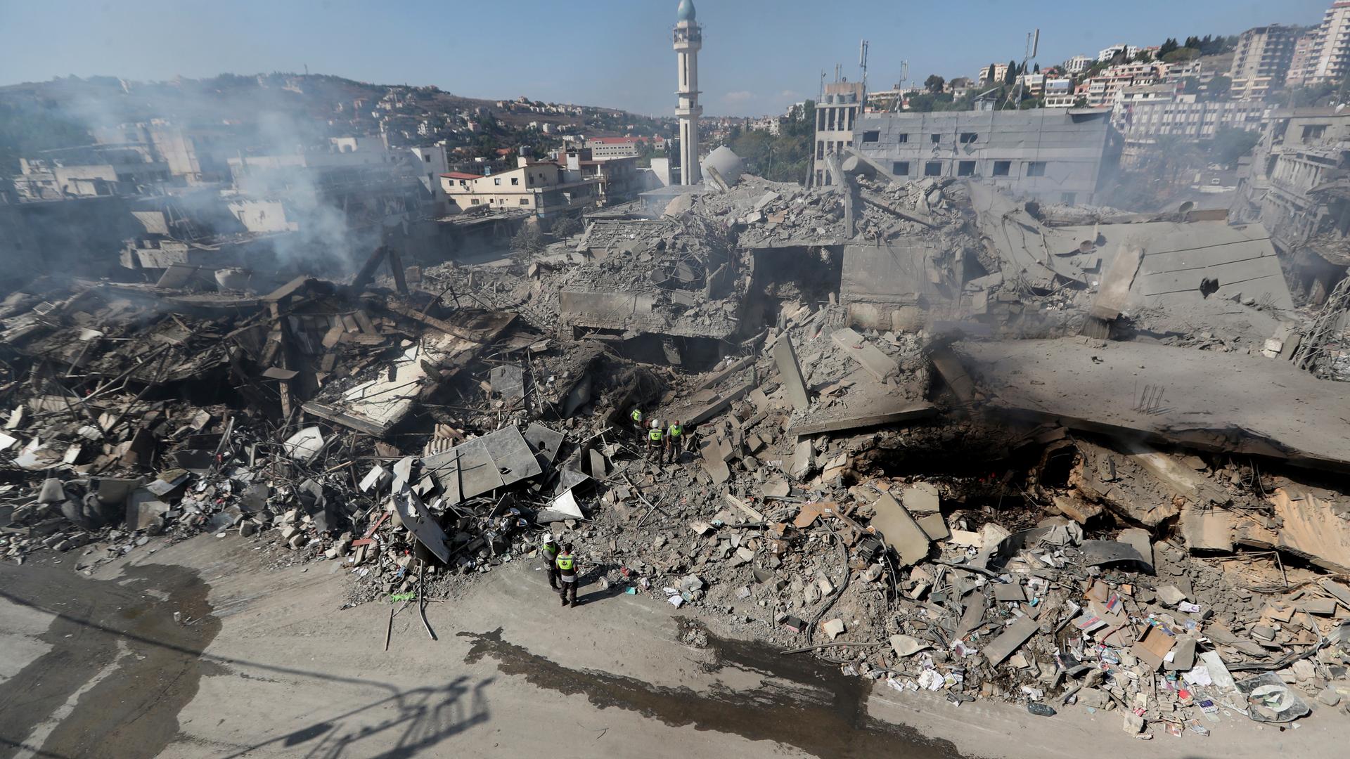 13.10.2024, Libanon, Nabatija: Rettungskräfte der Hisbollah suchen nach Opfern in den Trümmern zerstörter Gebäude in einer Geschäftsstraße, die am Samstagabend (12.10.2024) von israelischen Luftangriffen getroffen wurde.
